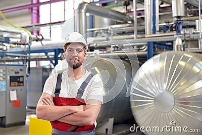 Portrait of successful smiling workers/ engineers on site in an industrial factory with helmet Stock Photo