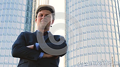 Portrait of a successful young handsome engineer, architect, builder, businessman, wearing a white helmet, in a suit, holding a pr Stock Photo