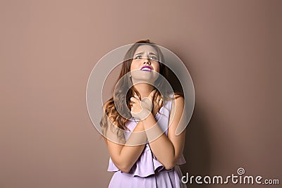 Portrait of suffering young woman on color background Stock Photo