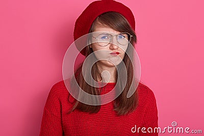 Portrait of sullen angry offended girl frowns face, pouts lips, being irritated,posing isolated over pink background, discontent Stock Photo