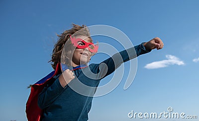 Portrait of superhero kid against blue sky background. Copy space. Stock Photo