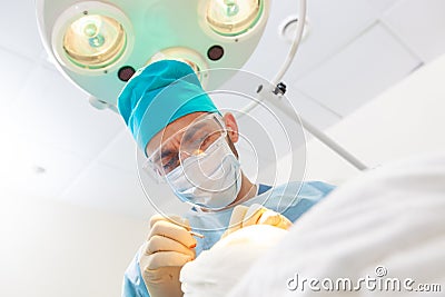 Portrait of a surgeon at work. Lamp in the background. The surgeon gives injections to the head. Hair transplant. Stock Photo