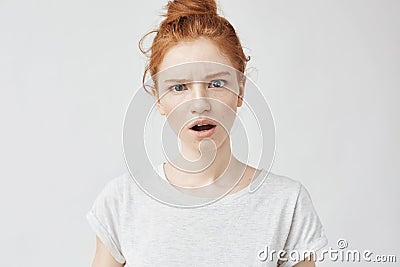 Portrait of surprised displeased freckled girl looking at camera. Copy space. Isolated on white. Stock Photo