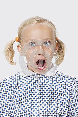 Portrait of a surprised young girl with mouth open over white background Stock Photo