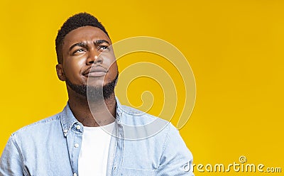 Portrait of suspicious black guy looking upwards at copy space Stock Photo