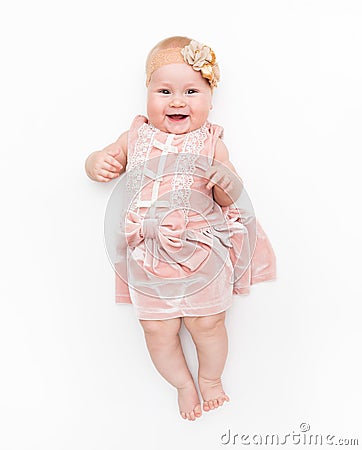 Portrait of a sweet infant wearing a pink dress, headband bow, isolated on white in studio. Stock Photo