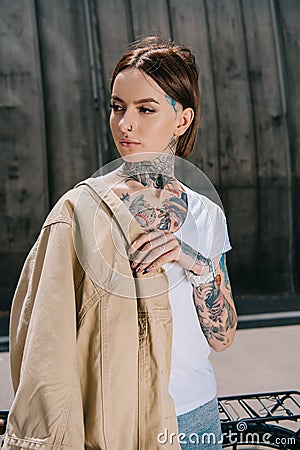 portrait of tattooed woman with jacket on shoulder Editorial Stock Photo