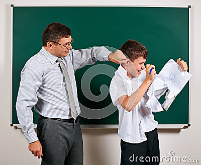 Portrait of a teacher catch the ear funny schoolboy with low discipline. Pupil very emotional, having fun and very happy, posing Stock Photo