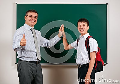 Portrait of a teacher and schoolboy playing at blackboard background - back to school and education concept Stock Photo