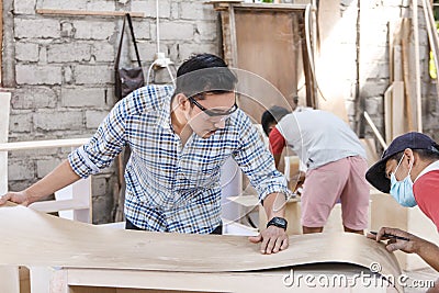 Teamwork building a furniture at carpenter workshop Stock Photo