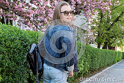 Portrait teen girl in glasses in flowering sakura park Stock Photo