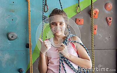 Portrait of teenage caucasian girl waiting for rock climbing. Sport, smiling with happiness and making thumb up. Activity and Stock Photo