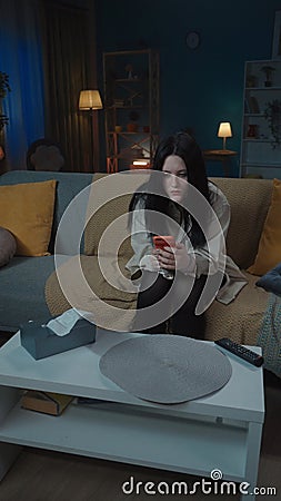 Portrait of teenage girl. Beautiful young girl in casual clothing sitting on the sofa in the apartment holding Stock Photo