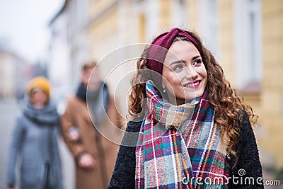 A portrait of teenage girl with headband and scarf on the street in winter. Stock Photo