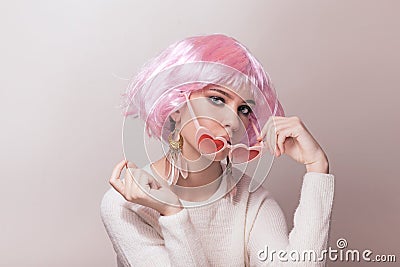 Portrait of teenage model with pink hair posing against pastel background Stock Photo