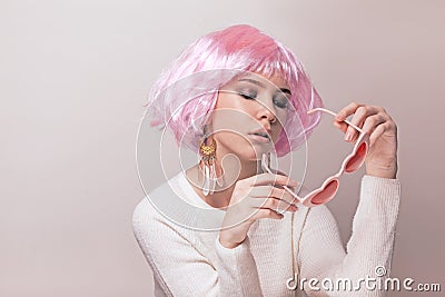 Portrait of teenage model with pink hair posing against pastel background Stock Photo