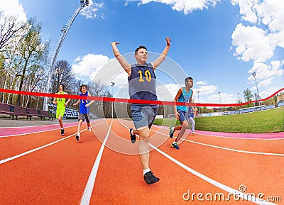 Portrait of teenage sprinter crossing finish line Stock Photo