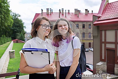 Portrait teenager student girl with woman teacher outside school Stock Photo