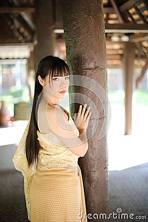 Portrait of Thai female with traditional Thai dress with temple background Stock Photo