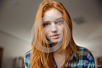 Portrait of thoughtful attractive redhead young woman in plaid shirt Stock Photo