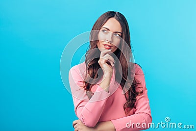 Portrait of thoughtful wondering woman looking sideways isolated over blue background Stock Photo