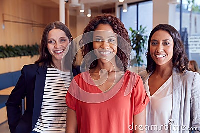 Portrait Of Three Businesswomen Standing In Modern Open Plan Office Together Stock Photo