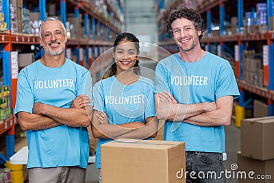 Portrait of three happy volunteers standing with arms crossed Stock Photo