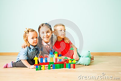 Portrait of three kids on a floor smiling to the camera Stock Photo