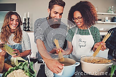 Three friends cooking spaghetti Stock Photo