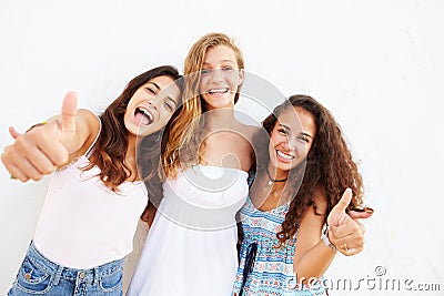 Portrait Of Three Teenage Girls Leaning Against Wall Stock Photo