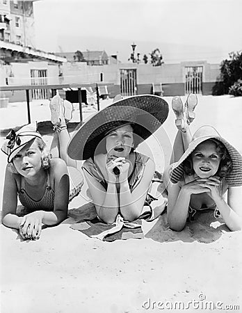 Portrait of three young women lying on the beach Stock Photo