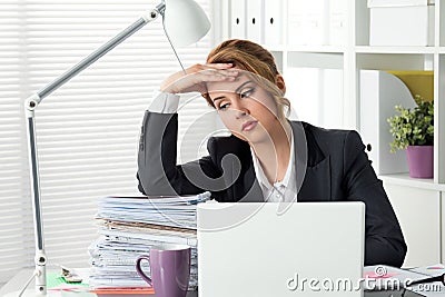 Portrait of tired businesswoman sitting at her office Stock Photo