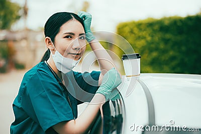 Portrait of tired exhausted nurse or doctor having a coffee break outside in the morning. COVID-19, Coronavirus pandemic Stock Photo