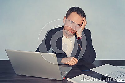 Portrait of tired male feeling headache while working with notebook computer at table. Fatigue during workaholismlabor with techno Stock Photo