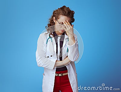 Tired modern doctor woman on blue Stock Photo