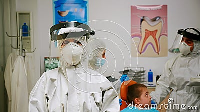 Portrait of tired stomatologist woman with coverall and face shield Stock Photo