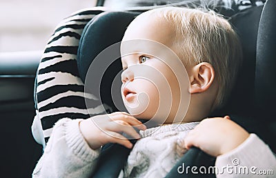 Portrait of toddler boy sitting in car seat. Stock Photo