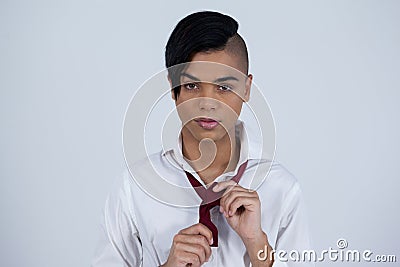 Portrait of transgender woman tying necktie Stock Photo