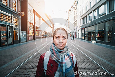 Portrait of traveler girl in scarf and with backpack on old street of Amsterdam, Netherlands. Europe travel concept Stock Photo