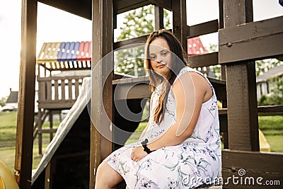 A Portrait of trisomie 21 adult girl outside at sunset Stock Photo