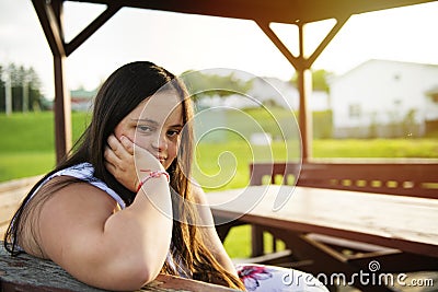 A Portrait of trisomie 21 adult girl outside at sunset Stock Photo