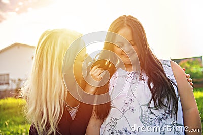 A Portrait of trisomie 21 adult girl smilin outside at sunset with family friend Stock Photo