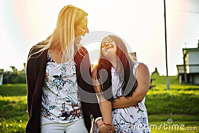 A Portrait of trisomie 21 adult girl smilin outside at sunset with family friend Stock Photo