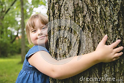 A portrait of trisomie 21 child girl outside having fun on a park Stock Photo