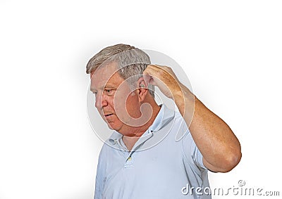 Portrait of trustful smiling mature man handling his hearing aid Stock Photo