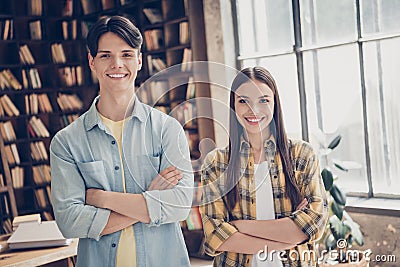 Portrait of two attractive cheerful smart friends learners folded arms visiting public library at loft industrial Stock Photo