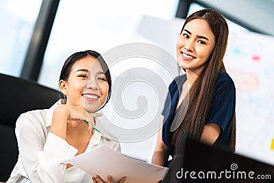 Portrait of two beautiful Asian office coworkers smiling together at work. Business colleagues, teamwork partner, job consultant Stock Photo