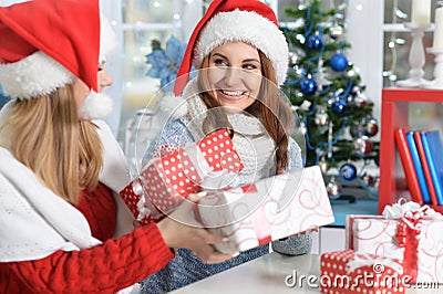 Portrait of two beautiful women opening Christmas presents Stock Photo