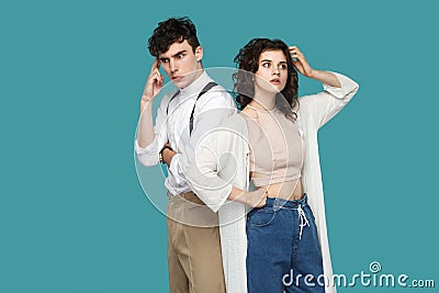 Portrait of two confused thoughtful brunette stylish partner standing, looking away, scratching head and thinking that to do and Stock Photo