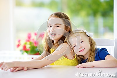 Portrait of two cute little sisters at home on beautiful summer day Stock Photo